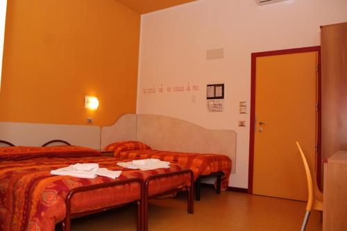 a hotel room with two beds and two tables at Hotel Nautic in Gatteo a Mare