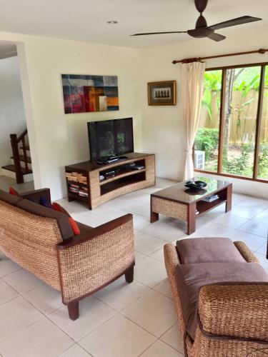 a living room with a television and a couch at Baan Laem Noi Villa's in Mae Nam