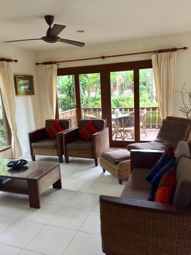 a living room with couches and chairs and a patio at Baan Laem Noi Villa's in Mae Nam