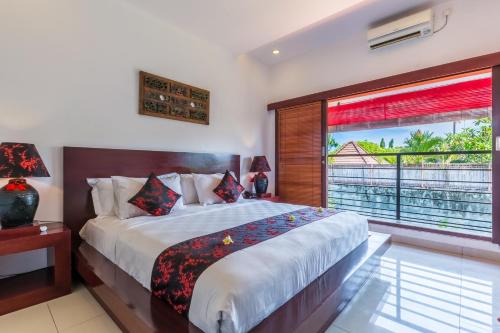 a bedroom with a large bed and a large window at Kamar Kamar Boutique Hotel in Seminyak
