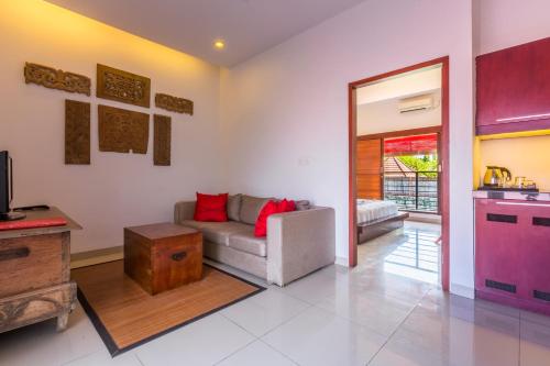 a living room with a couch and a table at Kamar Kamar Boutique Hotel in Seminyak