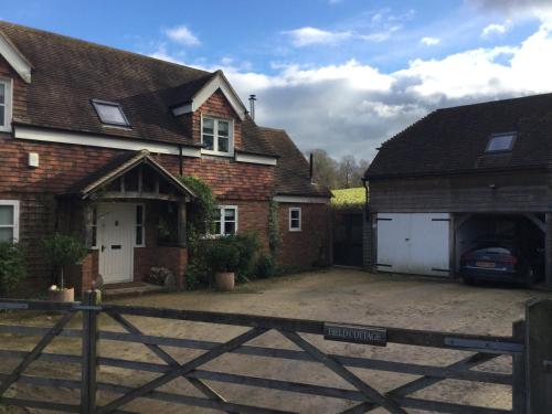 una casa con un garage e una macchina parcheggiata in esso di Field Cottage B&B a Haywards Heath