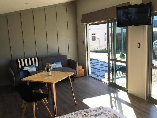 a living room with a table and a couch and a television at Kohimarama Beach Bed & Breakfast in Auckland