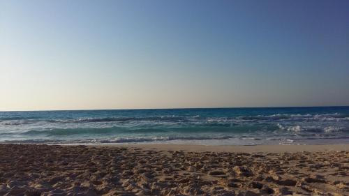 a sandy beach with the ocean in the background at El Zohour Chalet North Coast in El Alamein