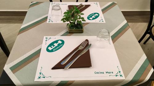 a table with a plate and a fork and knife at Lungomare Hotel in Marina di Cecina