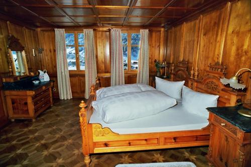 Un dormitorio con una gran cama de madera con almohadas blancas. en Villa 17, en Gaschurn