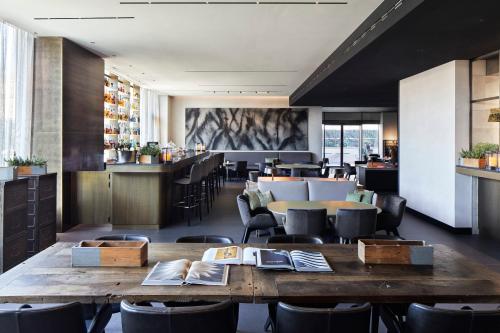 a restaurant with wooden tables and chairs and a bar at Hotel VIU Milan, a Member of Design Hotels in Milan