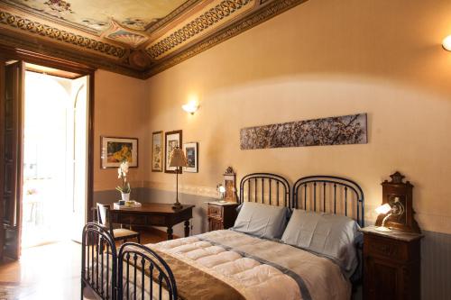 a bedroom with a bed and a table and a desk at Palazzo Melluso LUXURY SUITE in Porto Empedocle
