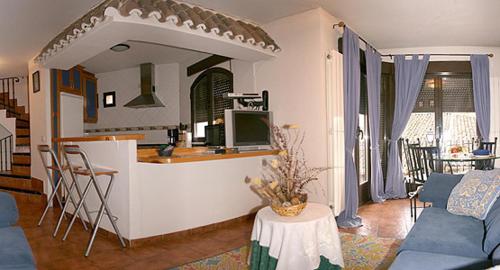 a living room with a couch and a kitchen at Casita Del Brezal in Rascafría