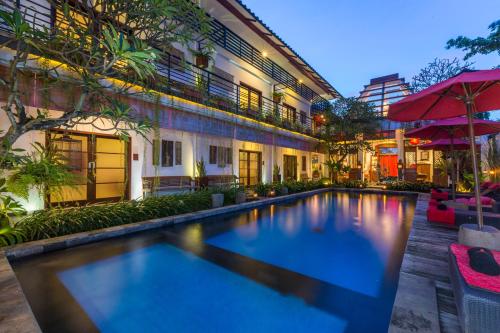 a swimming pool in front of a building at Kamar Kamar Boutique Hotel in Seminyak