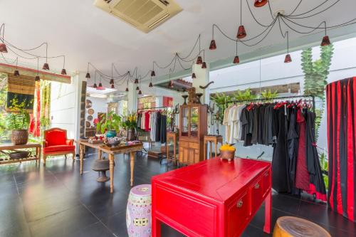 a clothing store with a red table in a room at Kamar Kamar Boutique Hotel in Seminyak