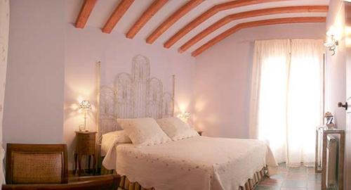 Schlafzimmer mit einem Bett mit weißer Bettwäsche und einem Fenster in der Unterkunft Zaguan in Rascafría