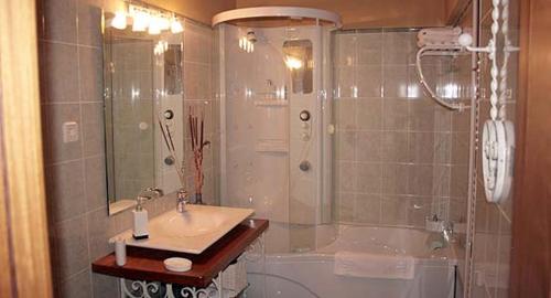 a bathroom with a shower and a sink and a tub at Zaguan in Rascafría