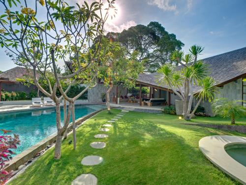 an image of a backyard with a swimming pool and trees at The Layar - Designer Villas and Spa, CHSE Certified in Seminyak
