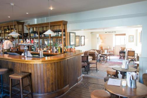 a bar in a restaurant with tables and chairs at The Swan in Wedmore
