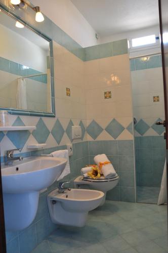 a bathroom with a sink and a toilet and a mirror at Hotel CASA LA VIGNA in Ischia