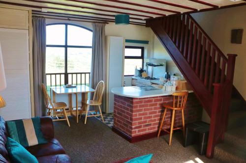 a living room with a kitchen and a table with chairs at Bank Top Farm Cottages in Stoke on Trent