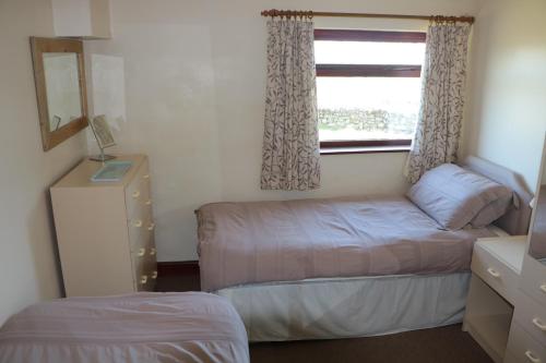 a small bedroom with a bed and a window at Bank Top Farm Cottages in Stoke on Trent