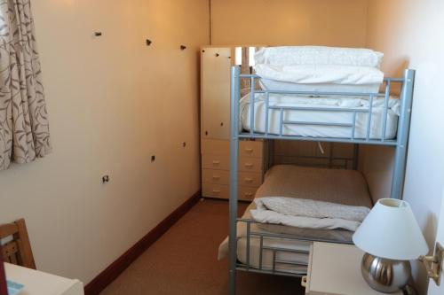 a bunk bed in a room with a desk and a lamp at Bank Top Farm Cottages in Stoke on Trent