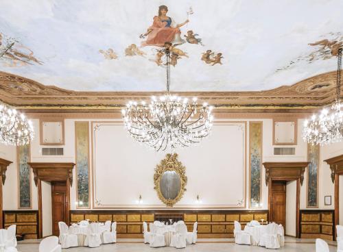 a banquet hall with a chandelier and white tables at Grand Hotel Telese in Telese