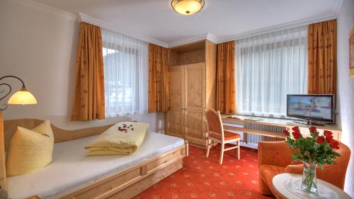 una camera d'albergo con letto e TV di Hotel-Garni Weidacherhof a Leutasch