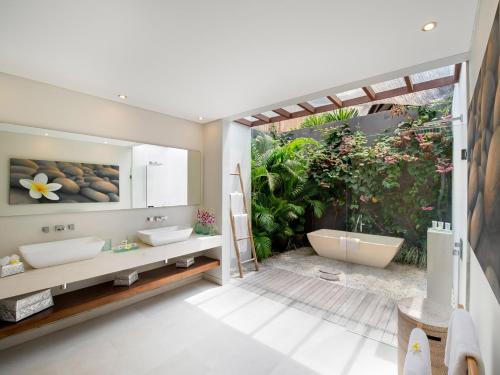 a bathroom with two sinks and a bath tub at The Layar - Designer Villas and Spa, CHSE Certified in Seminyak