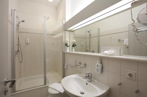 ein Bad mit einem Waschbecken, einer Dusche und einem Spiegel in der Unterkunft Landhaus Schieder in Schieder-Schwalenberg