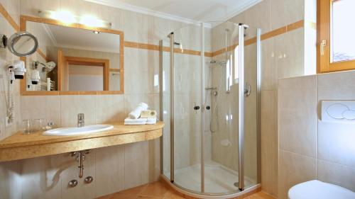 uma casa de banho com um chuveiro e um lavatório. em Hotel-Garni Weidacherhof em Leutasch