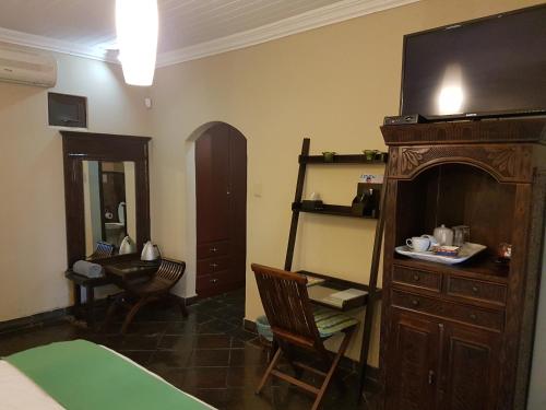 a room with a bed and a television and a chair at Santai guesthouse in Brits
