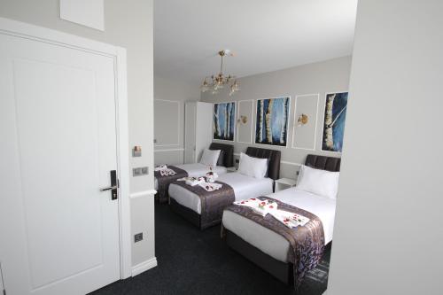 a hotel room with two beds and a door at Hotel Naumpasa Konagi in Istanbul