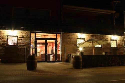 an umbrella in front of a store at night at Weingut Schumacher - mit privatem Saunabereich in Sankt Aldegund