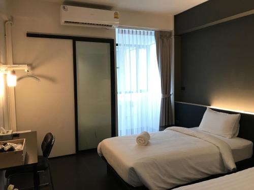 a hotel room with a bed and a window at Shane Hotel in Chiang Mai