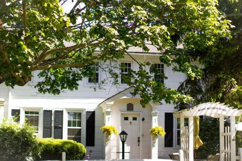 a white house with black windows and a door at Historic White Blossom House in Southold
