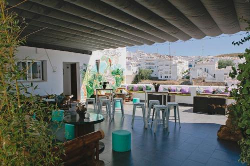 a patio with tables and chairs and a view of the city at Hotel Posada de las Cuevas in Arcos de la Frontera