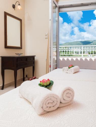 a bedroom with a bed with towels and a desk at Lorenzo Villas with Private Pool, 200m from the beach, by ZanteWize in Lithakia