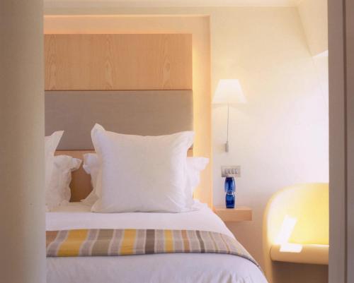 a bedroom with a bed with white sheets and pillows at Sydney House Chelsea in London
