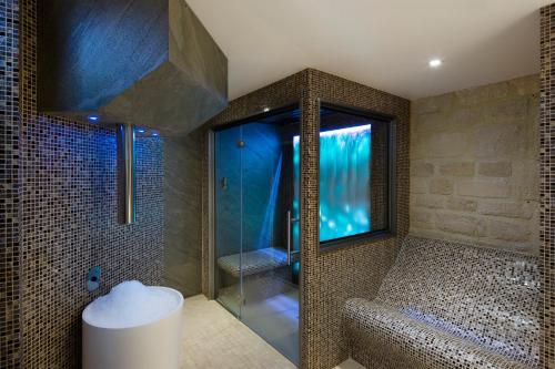 a bathroom with a shower with a glass door at Hotel & Spa de Latour Maubourg in Paris