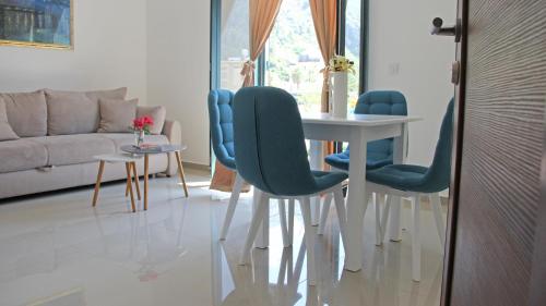 a living room with a table and blue chairs at Filipa Apartment in Kotor