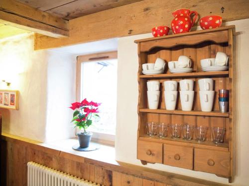 une étagère avec des tasses et de la vaisselle dans une cuisine dans l'établissement Charming luxury chalet with sauna, à Morzine