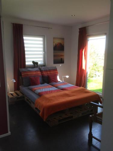 a bedroom with a large bed with red curtains at Maison Marguerite in Lemiers