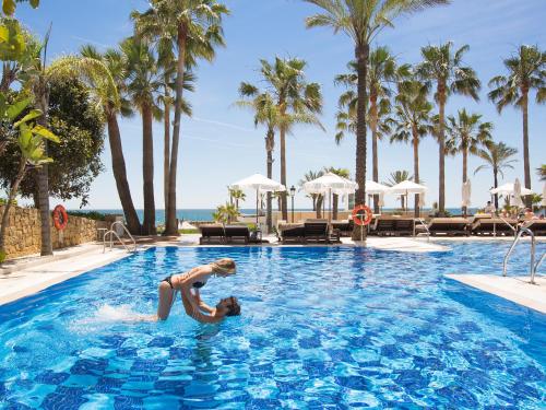 a woman in a swimming pool at a resort at Amàre Beach Hotel Marbella - Adults Only Recommended in Marbella
