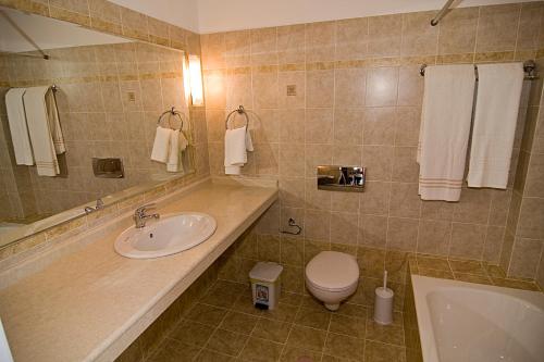 a bathroom with a sink and a toilet and a tub at Sifis Studios Pefkos in Pefki Rhodes