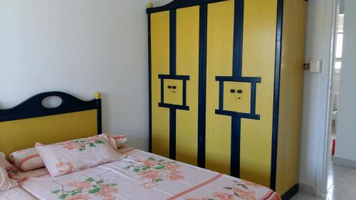 a bedroom with a bed with a yellow and black headboard at El Zohour Chalet North Coast in El Alamein