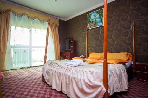 una camera da letto con un letto a baldacchino e asciugamani di La Grand Chez Johnson Hotel Muyenga a Kampala