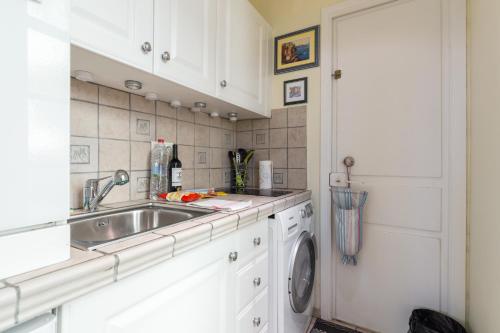 cocina con fregadero y lavadora en Very charming studio apartment on port in Cannes a short walk to Palais with Aircon and internet 411, en Cannes