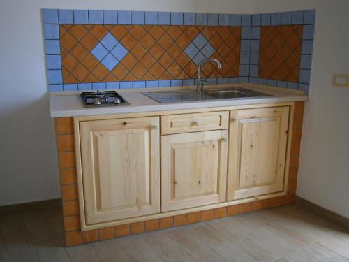 a kitchen with a sink and a tile wall at Appartamenti Da Nicola in Lampedusa