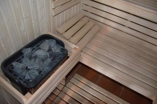 an inside of a sauna with a tray of rocks at Jaś i Małgosia nad Jeziorem Wigry in Rosochaty Róg
