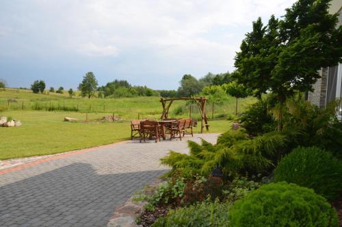 a patio with tables and a gazebo in a field at Jaś i Małgosia nad Jeziorem Wigry in Rosochaty Róg