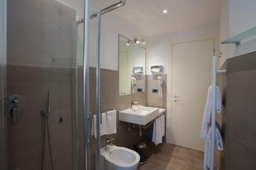 a bathroom with a sink, toilet and shower at Hotel Astoria in Rapallo