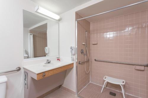 y baño con ducha, lavabo y aseo. en Super 8 by Wyndham Germantown/Milwaukee, en Germantown